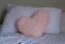 Children's Shoes And Clothes On The Bed. Beautiful Pink Baby Clo